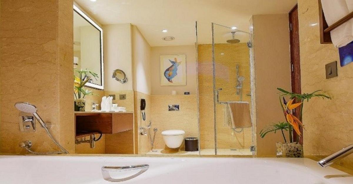 a large bathroom with a tub and a shower at Radisson Blu Plaza Hotel Mysore in Mysore