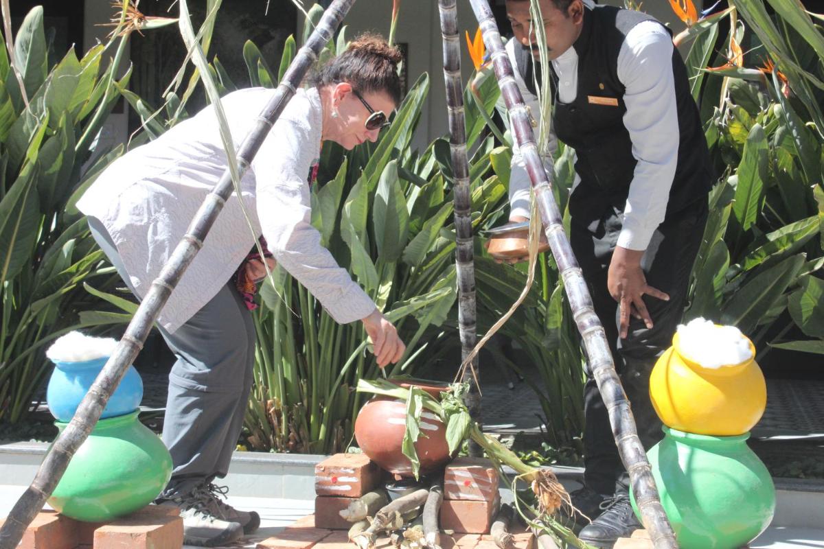 two men are looking at plants in a garden at Savoy - IHCL SeleQtions in Ooty
