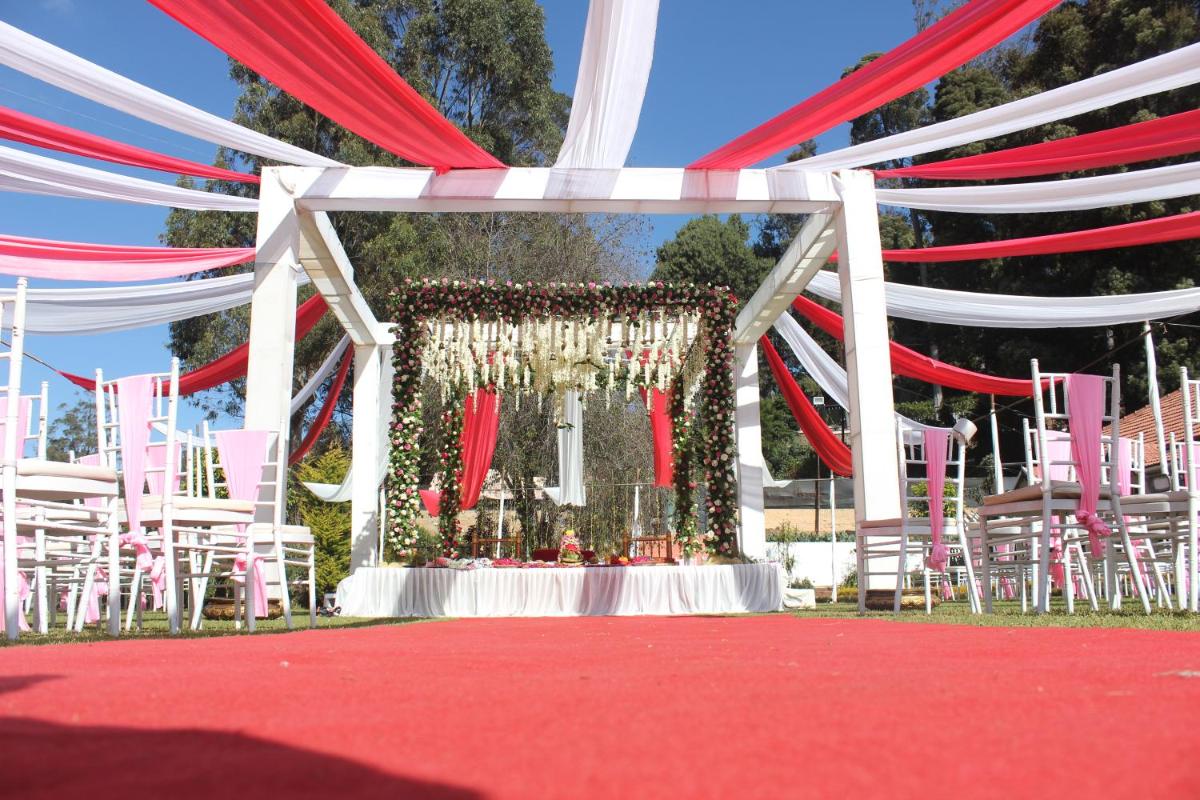 a set up for a wedding with red and white chairs at Savoy - IHCL SeleQtions in Ooty