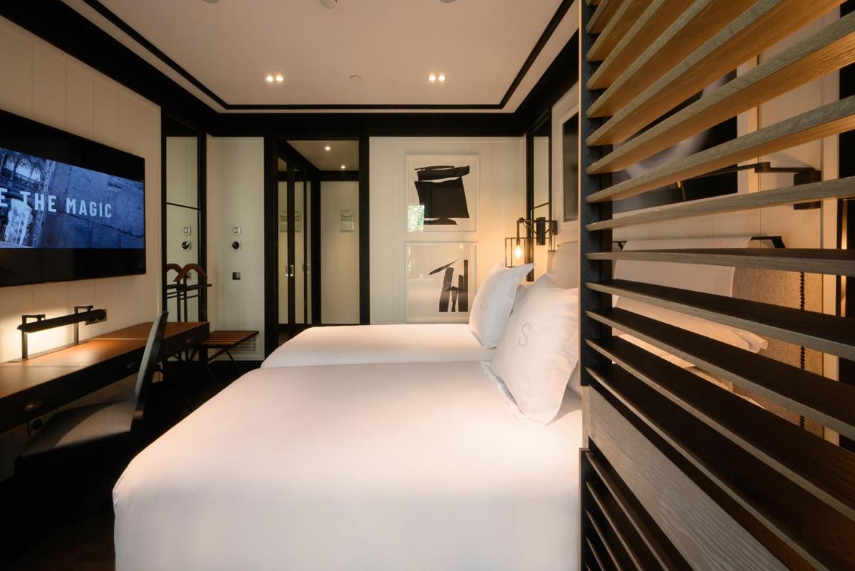 Una habitación de hotel con dos camas y un televisor. en Seventy Barcelona, en Barcelona