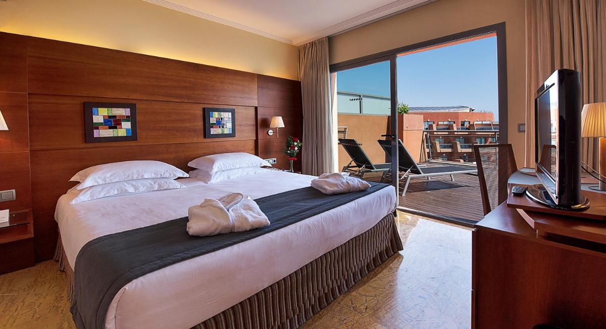 Una habitación de hotel con una cama grande y un televisor. en Protur Roquetas Hotel & Spa, en Roquetas de Mar