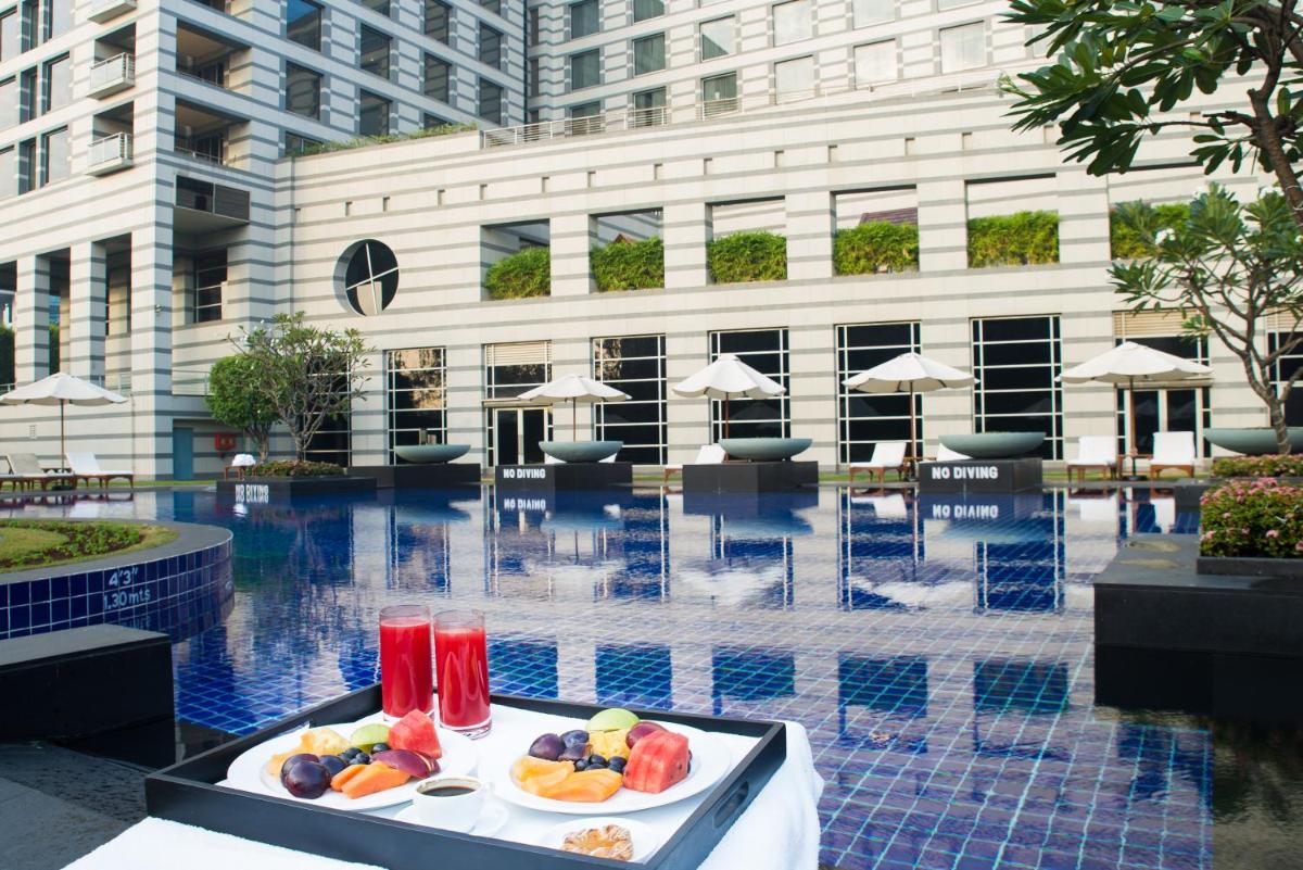 a tray of fruit on a table next to a pool at Grand Hyatt Mumbai Hotel and Residences in Mumbai