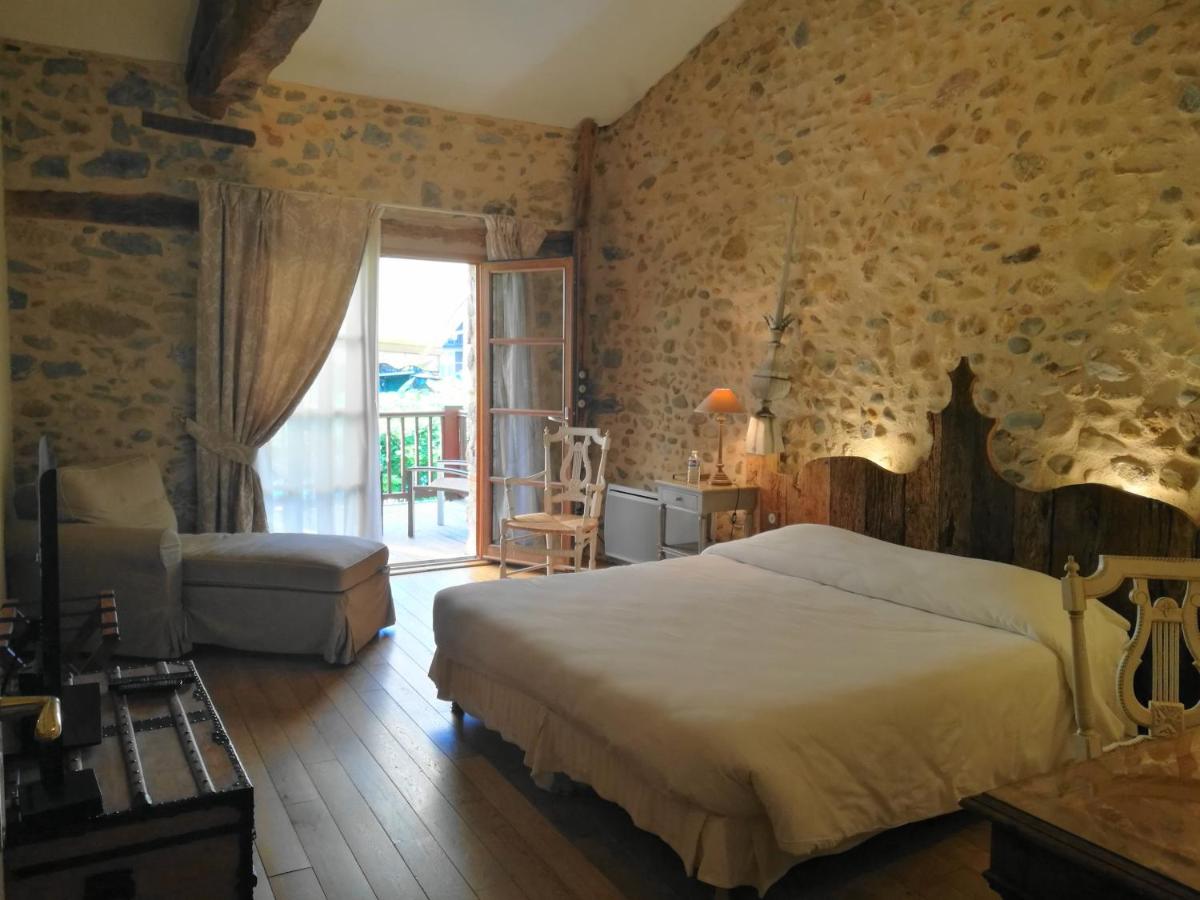 une chambre avec un lit, une chaise et une fenêtre dans l'établissement Hotel Logis - Chateau de Beauregard, à Saint-Girons 66 autres photos