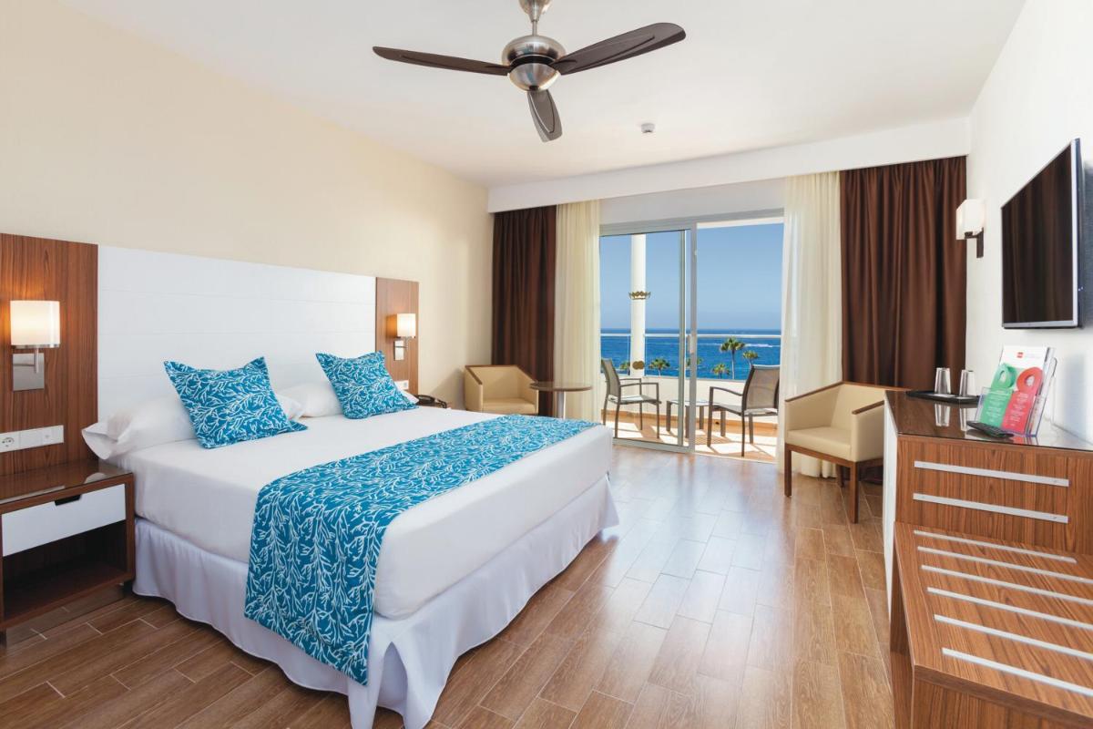 Un dormitorio con una cama y vista al mar. en Hotel Riu Arecas - Adults Only, en Adeje