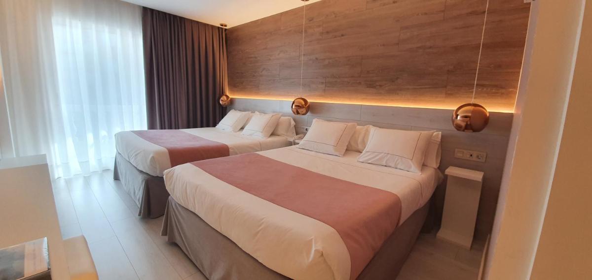 Dos camas en una habitación de hotel con dos personas. en Hotel Bernat II 4*Sup, en Calella 30 fotos más