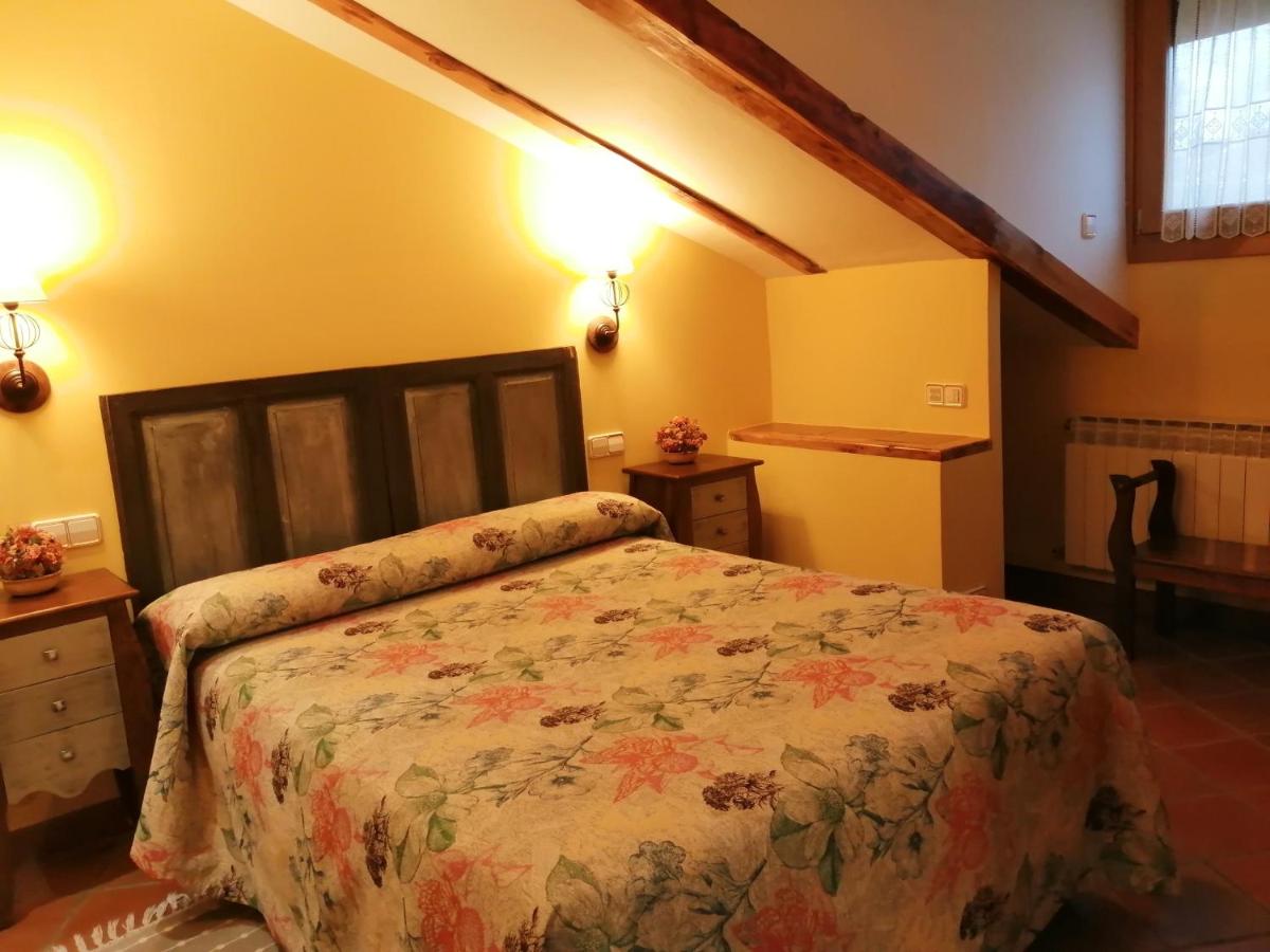 Un dormitorio con una cama y dos luces en la pared. en Hotel Rural & SPA Puente del Duratón, en Sepúlveda 57 fotos más