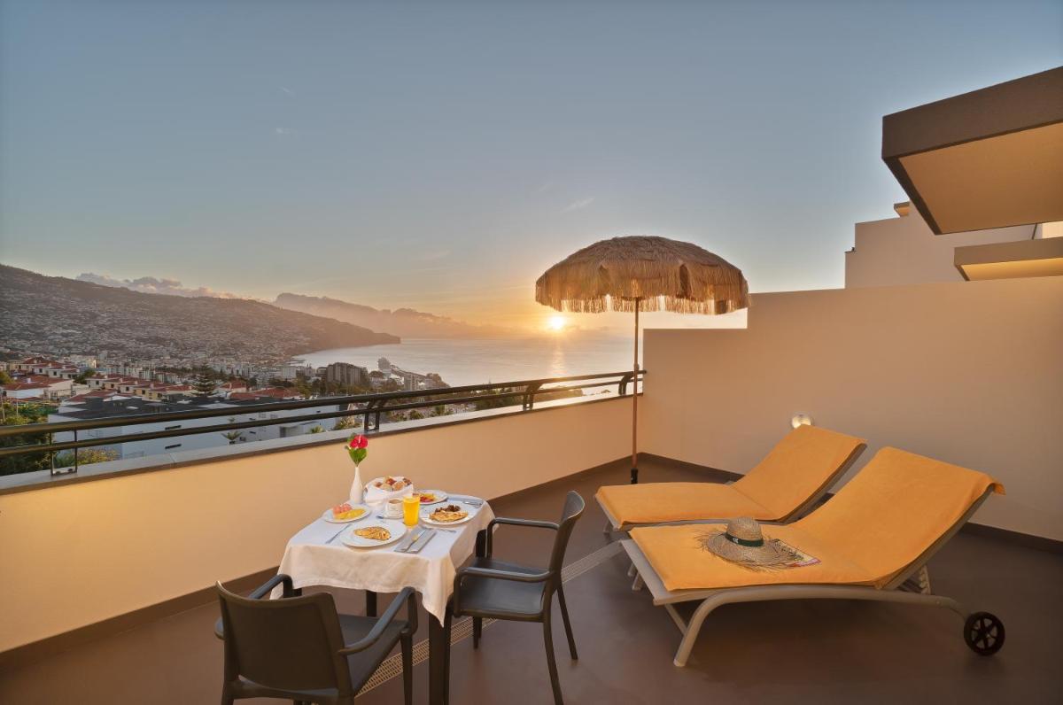 uma varanda com mesa e cadeiras e vista em Madeira Panorâmico Hotel no Funchal