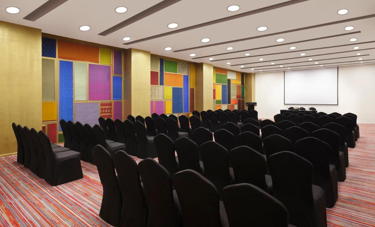 an empty conference room with chairs and a screen at Crowne Plaza Pune City Centre by IHG in Pune