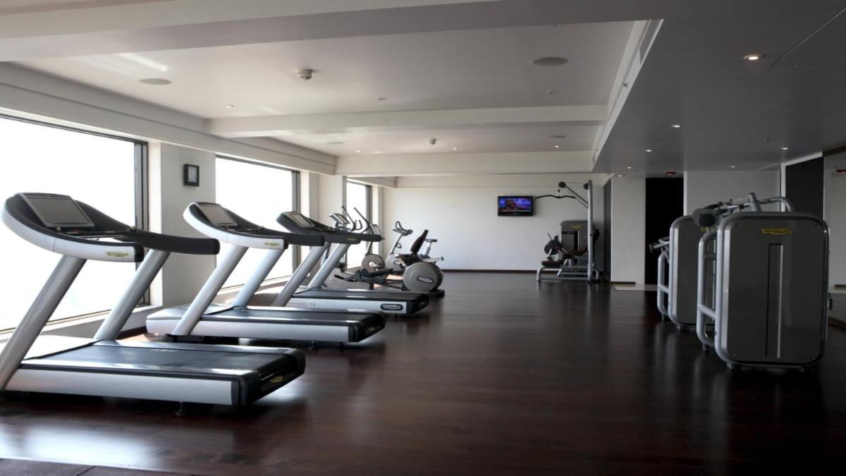 a gym with a row of treadmills and machines at Crowne Plaza Pune City Centre by IHG in Pune