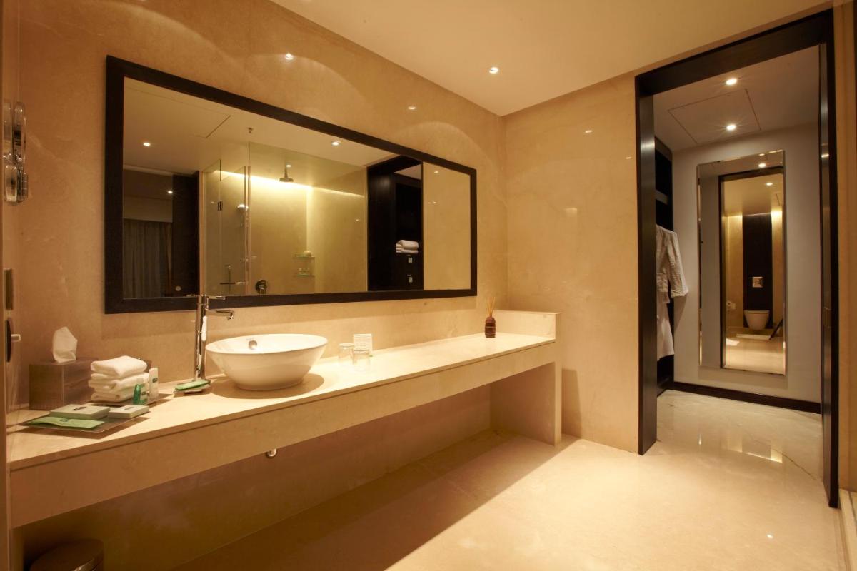 a bathroom with a sink and a large mirror at Crowne Plaza Pune City Centre by IHG in Pune