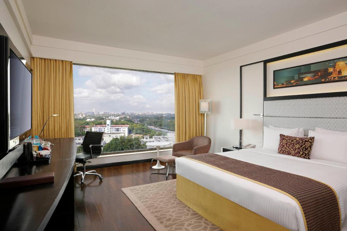a hotel room with a bed and a large window at Crowne Plaza Pune City Centre by IHG in Pune