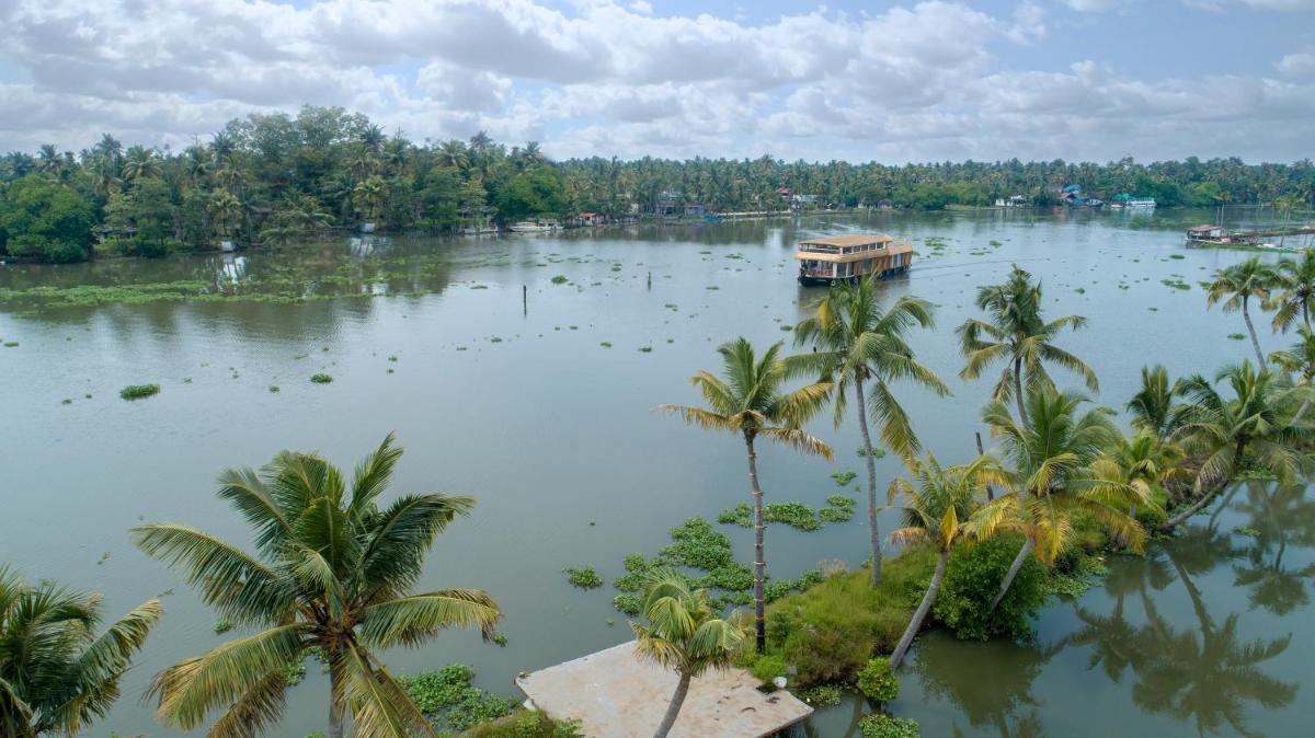 a boat in the middle of a river with palm trees at Grand Hyatt Kochi Bolgatty in Cochin