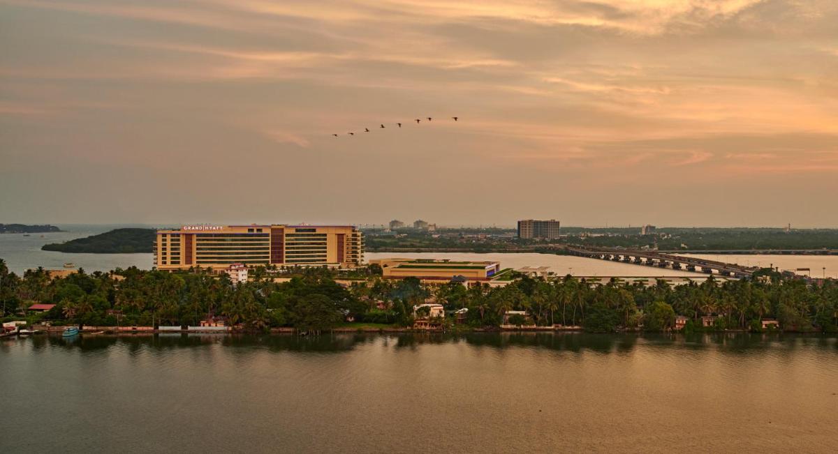 a group of birds flying in the sky over the water at Grand Hyatt Kochi Bolgatty in Cochin