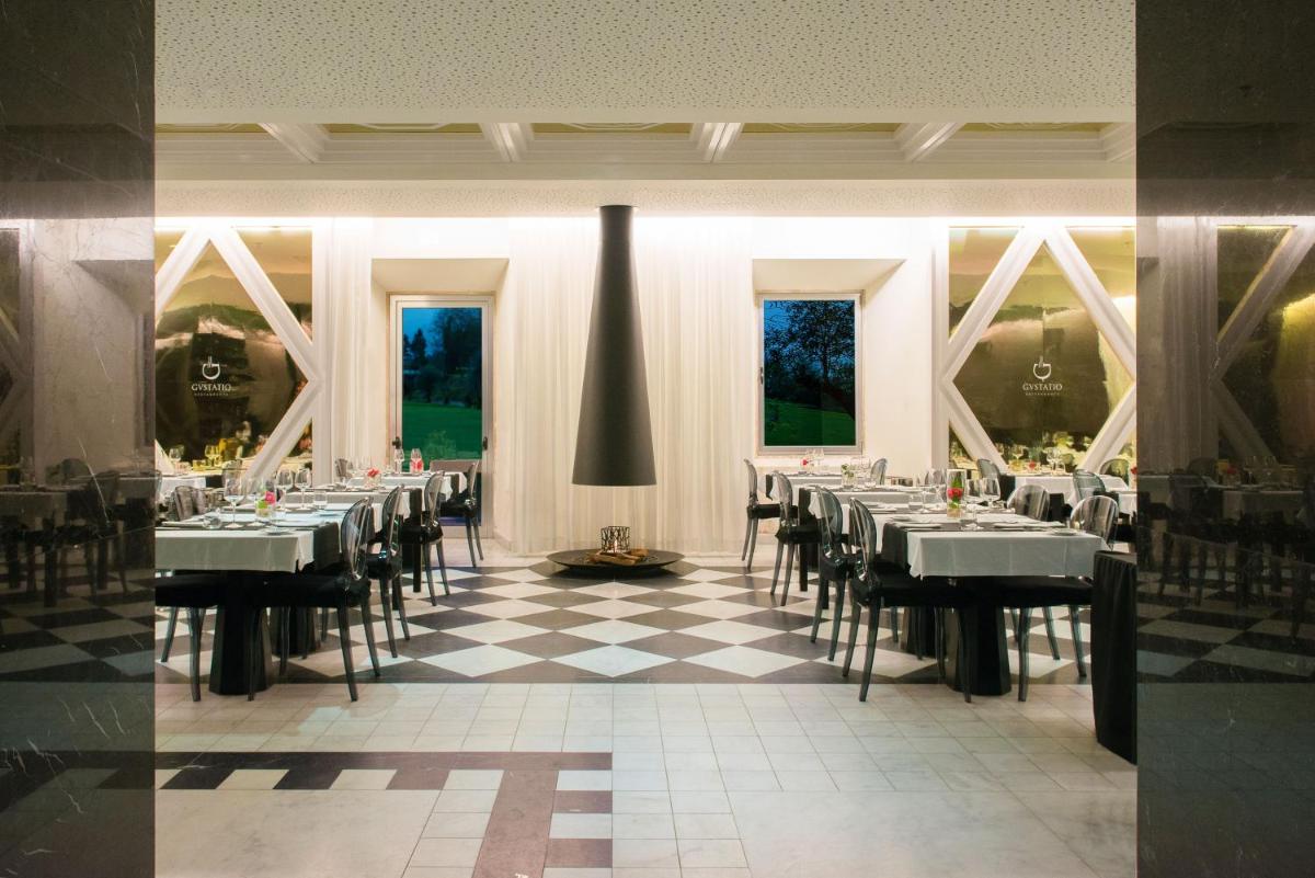 uma sala de jantar com mesas e cadeiras em um piso xadrez em HD