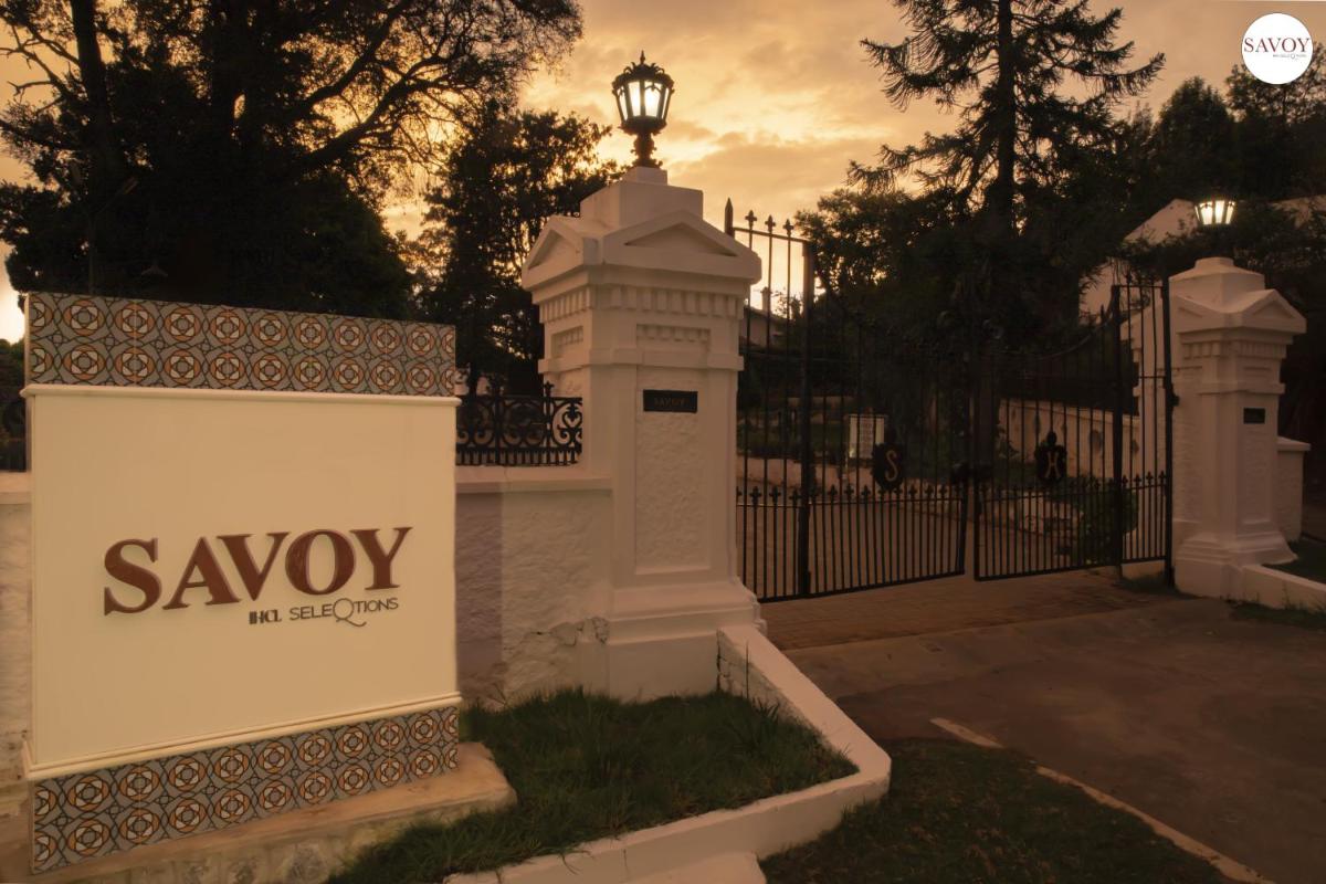a white fence with a sign in front of a gate at Savoy - IHCL SeleQtions in Ooty