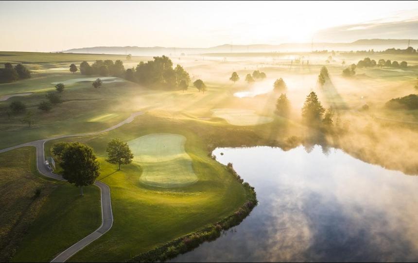 einen Luftblick auf einen Golfplatz mit See in der Unterkunft Der Öschberghof - Die 101 besten Hotels in Donaueschingen