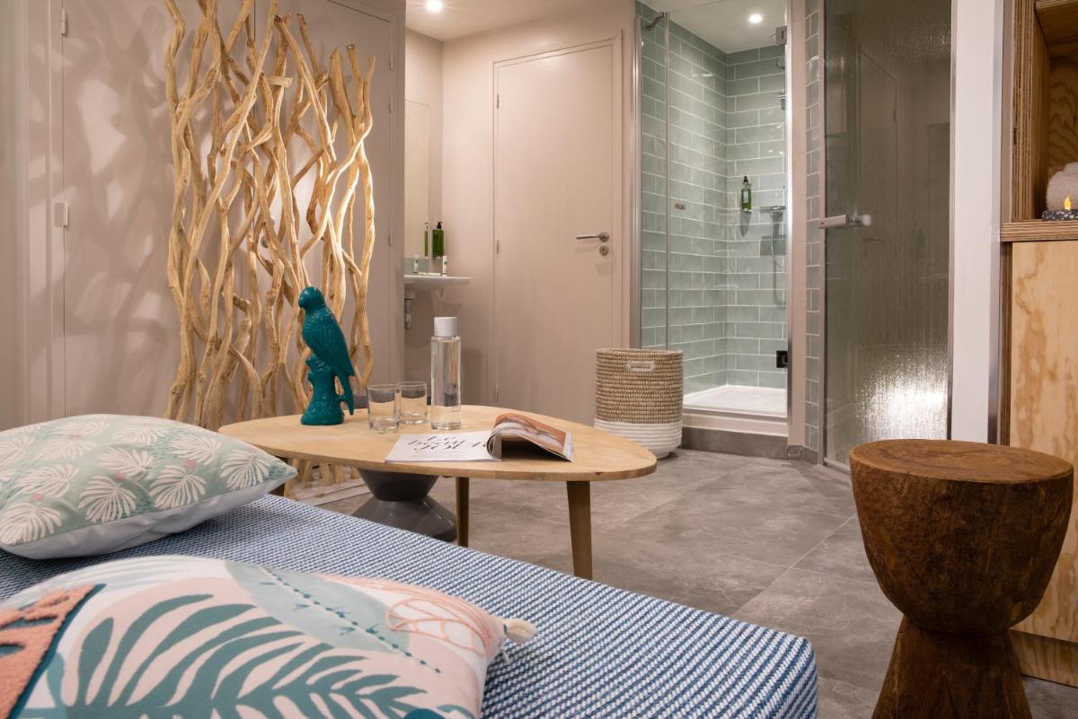 - une chambre avec un lit, une table et une douche dans l'établissement Hotel Locomo - Gare de Lyon Bastille, à Paris