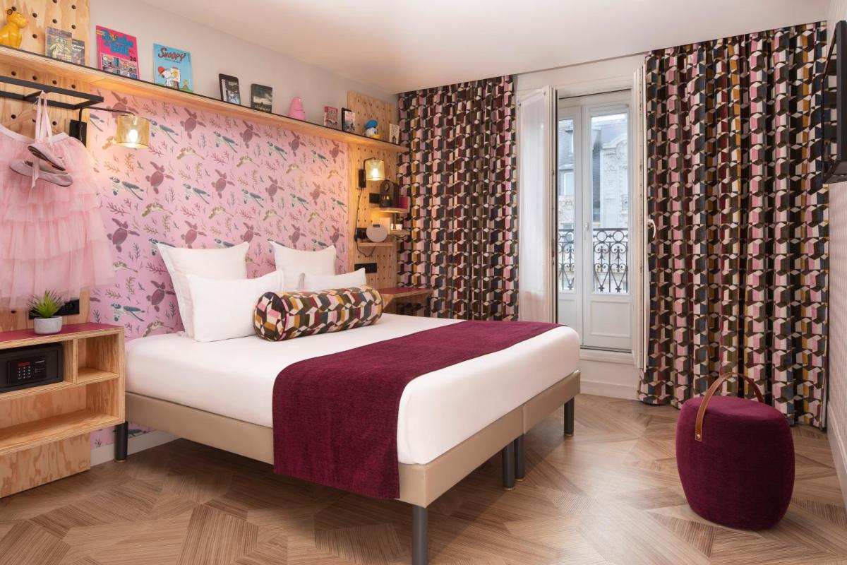 - une chambre avec un grand lit et un mur rose dans l'établissement Hotel Locomo - Gare de Lyon Bastille, à Paris