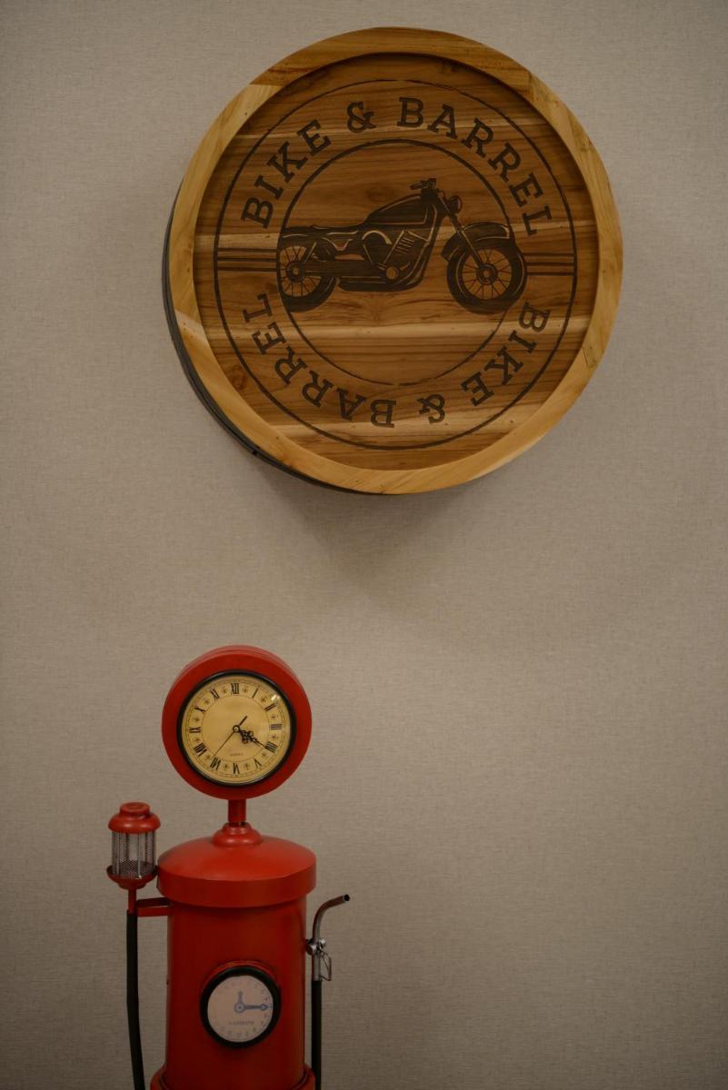 a picture of a motorcycle hanging on a wall with a clock at The Residency Towers Puducherry in Puducherry
