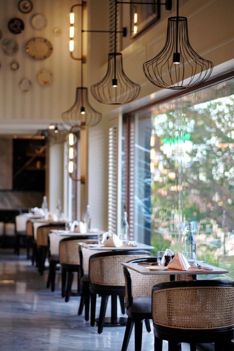a dining room with tables and chairs in a restaurant at The Residency Towers Puducherry in Puducherry