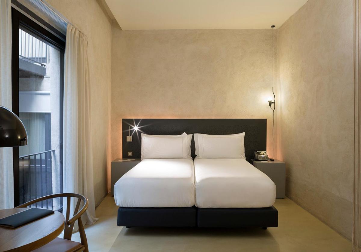 Cama o camas de una habitación en EME Catedral Mercer Hotel