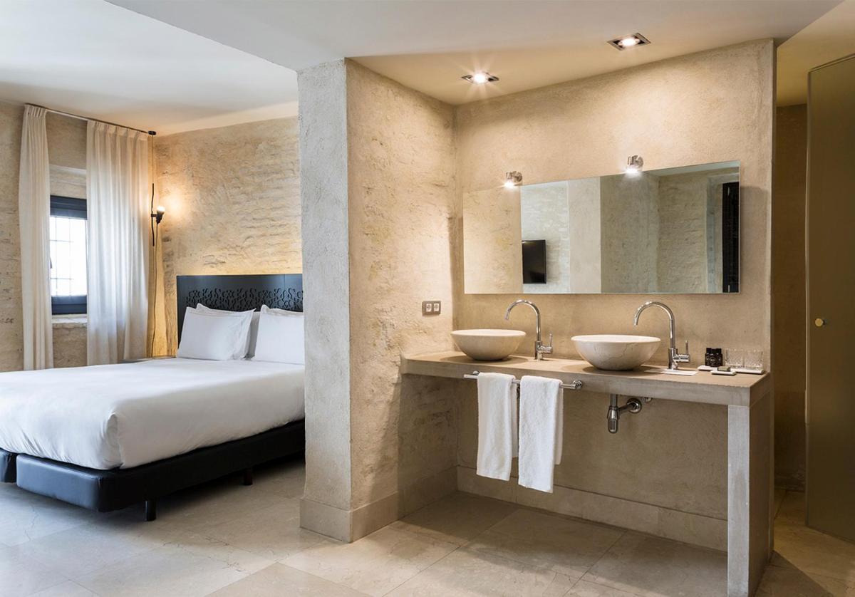 Una habitación de hotel con dos lavabos y una cama. en EME Catedral Mercer Hotel, en Sevilla