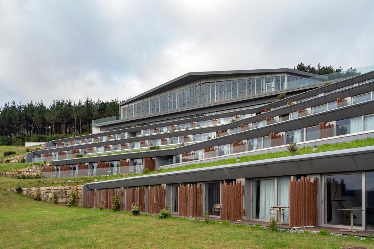 un gran edificio con plantas a su lado en Parador Costa da Morte, en Muxía