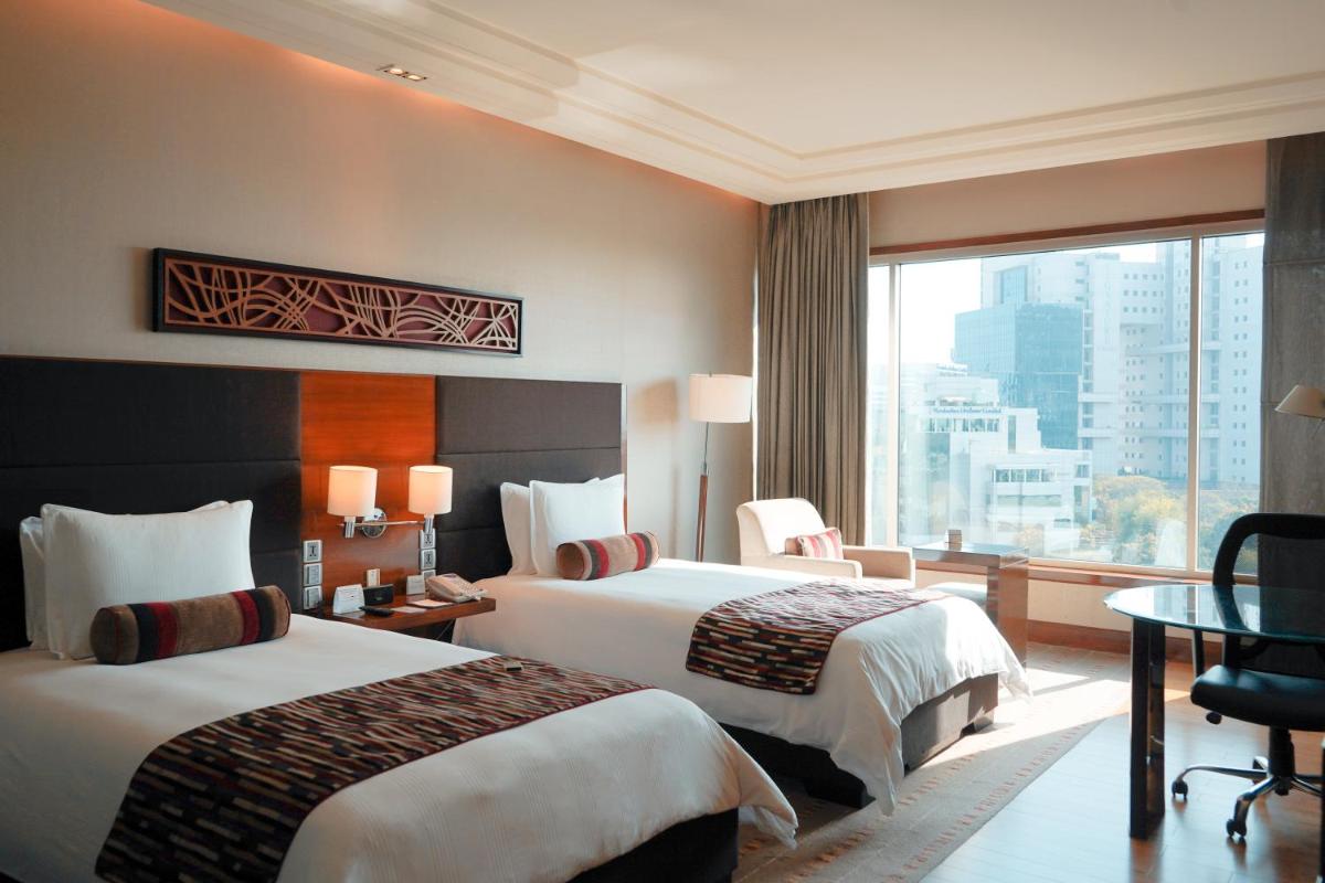 a hotel room with two beds and a large window at Crowne Plaza Today Gurugram by IHG in Gurgaon