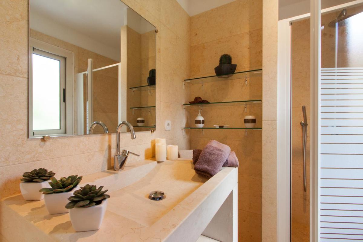 une salle de bain avec un grand lavabo et un miroir dans l'établissement Erbalunga - Résidence Les Bosquets - Cap corse Location, à Brando
