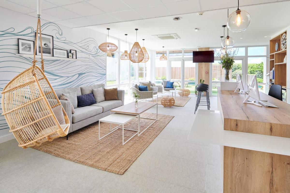 - un salon avec un canapé et une balançoire dans l'établissement Les Terrasses d'Atlanthal, à Anglet