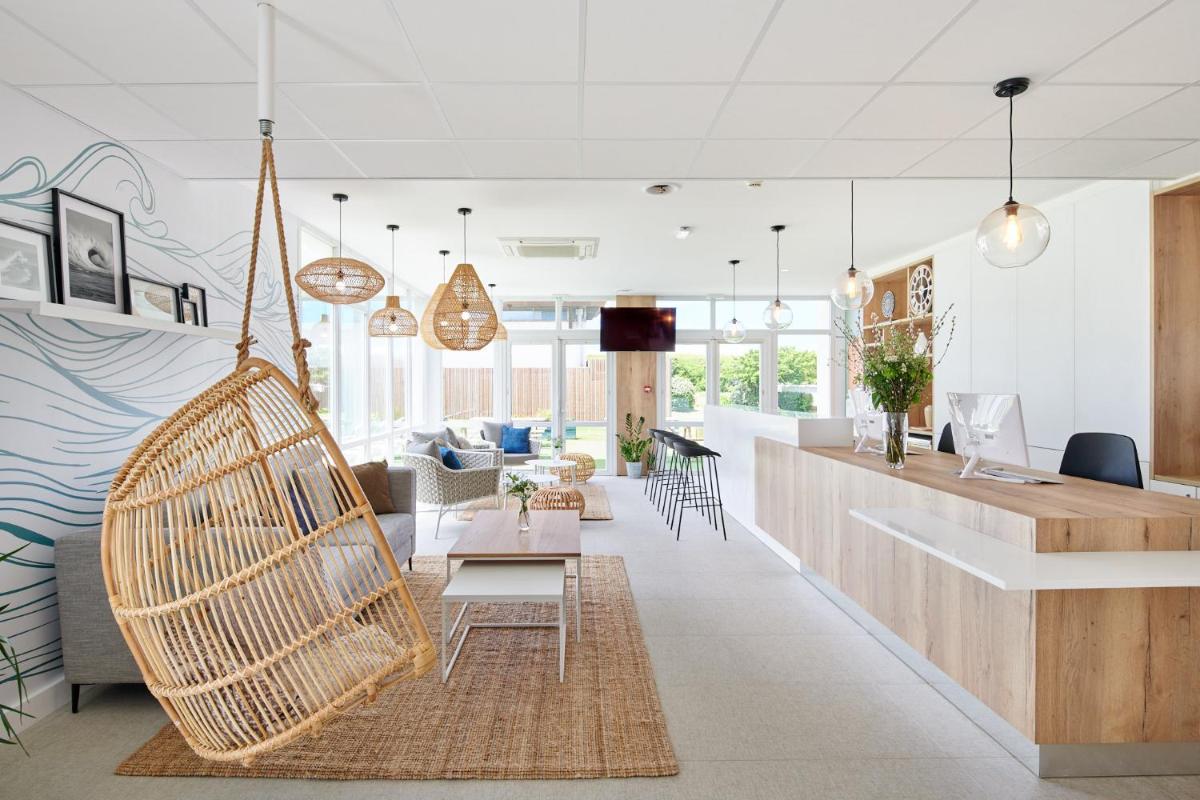 - un salon avec un hamac suspendu en rotin dans l'établissement Les Terrasses d'Atlanthal, à Anglet
