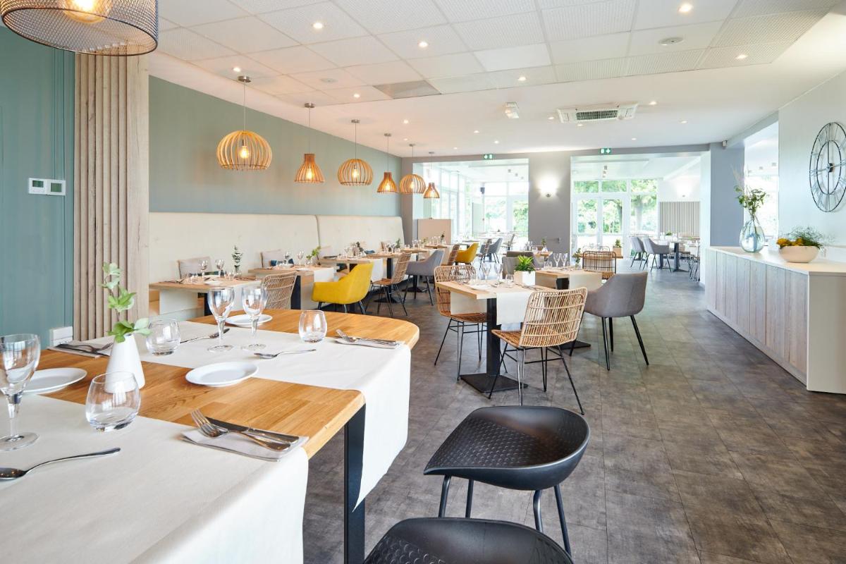 un restaurant avec des tables blanches et des chaises jaunes dans l'établissement Les Terrasses d'Atlanthal, à Anglet