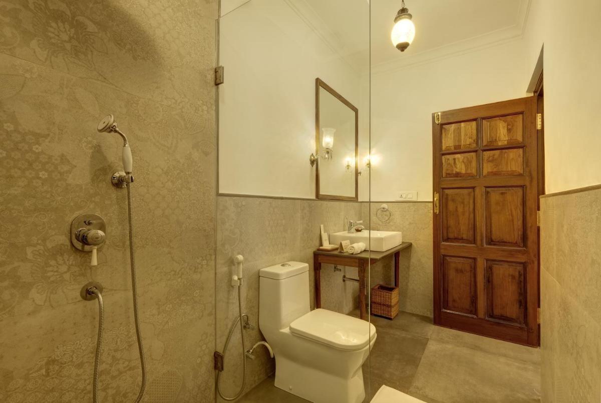 a bathroom with a toilet and a shower and a sink at Saraca Hotel Lucknow in Lucknow