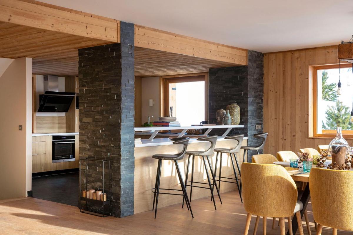 Il comprend une cuisine et une salle à manger avec une cheminée en briques. dans l'établissement Grandes Rousses Hotel & Spa, à L'Alpe-d'Huez