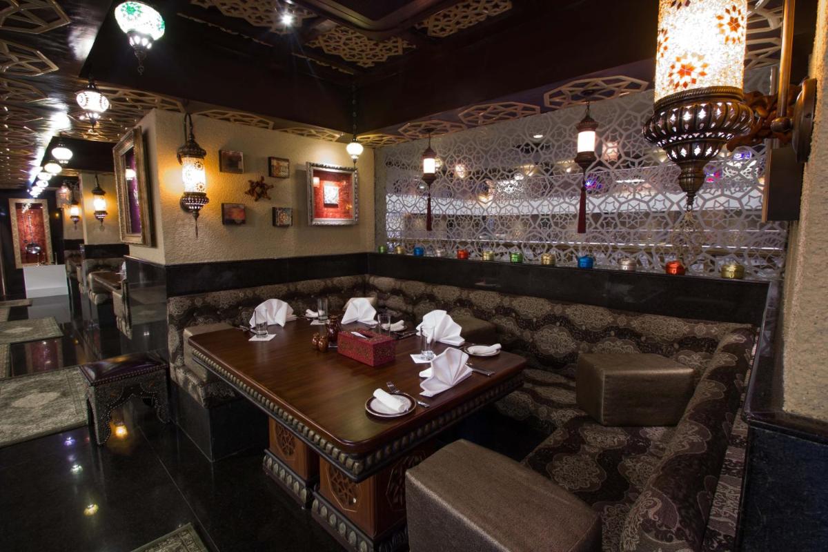 a restaurant with a wooden table and a bar at Sterlings Mac Hotel in Bengaluru