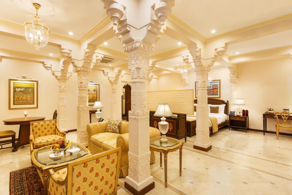 a large room with a bed and a living room at Taj Fateh Prakash Palace Udaipur in Udaipur