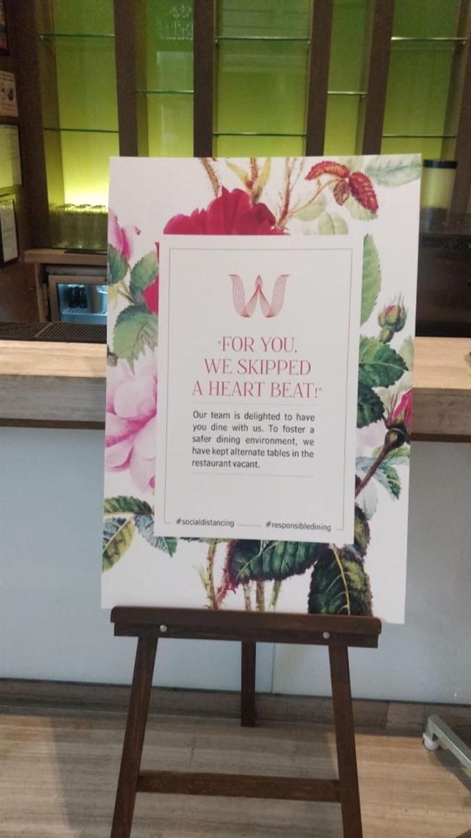 a sign sitting on top of a wooden bench at Welcomhotel by ITC Hotels, Richmond Road, Bengaluru in Bengaluru