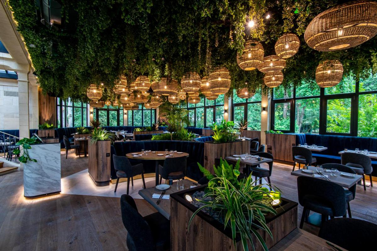 un restaurant avec des plantes au plafond et des lustres dans l'établissement Les Jardins d'Epicure, à Bray-et-Lû