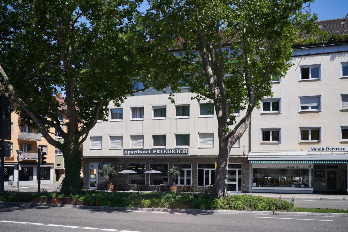 ein großes weißes Gebäude mit Bäumen davor in der Unterkunft Friedrich Boutique-Apartments in Freiburg im Breisgau