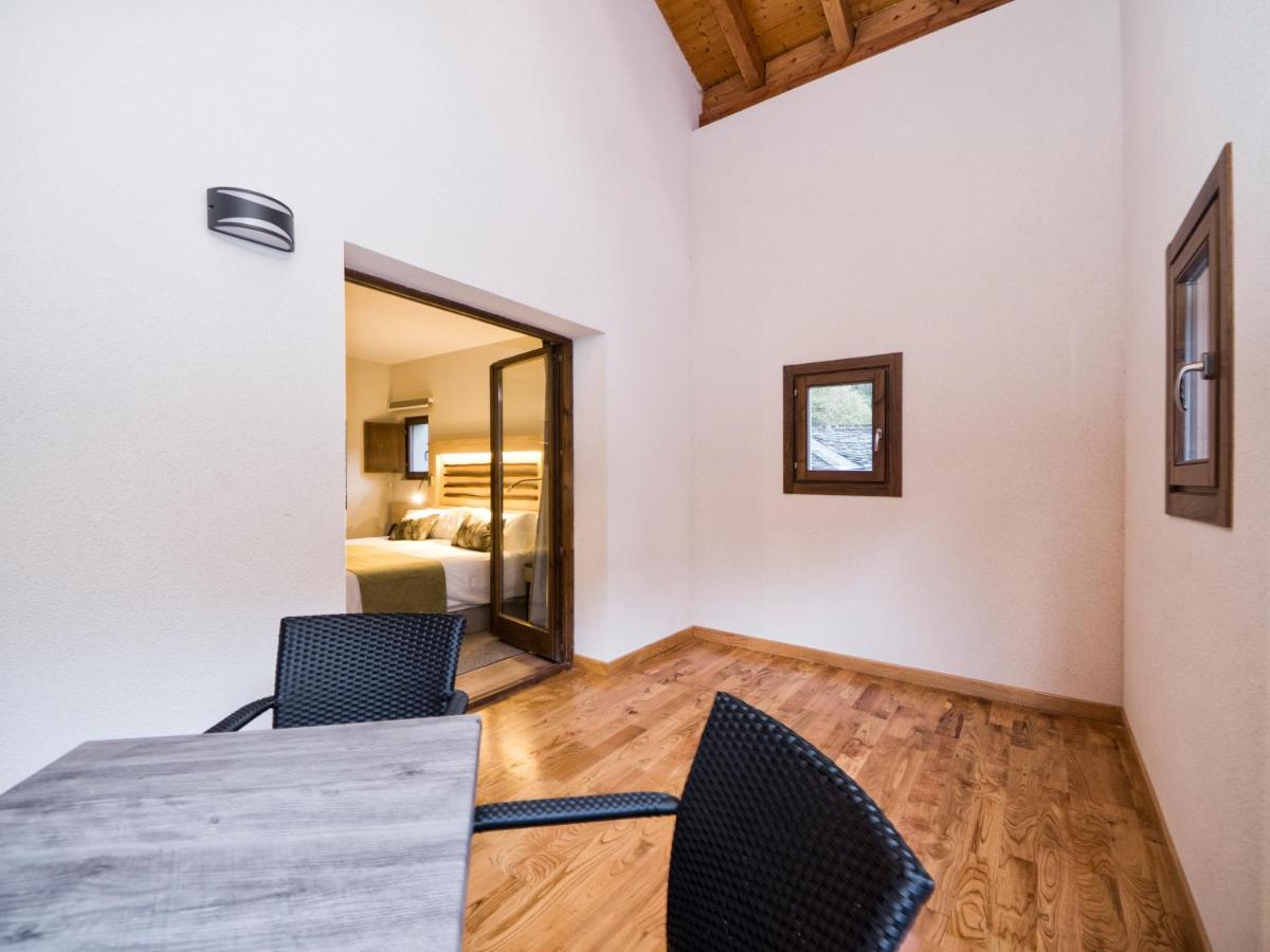 una habitación con una mesa y dos sillas y una cama en Hotel Rural Las Montañas de Pumar, en Besullo 58 fotos más