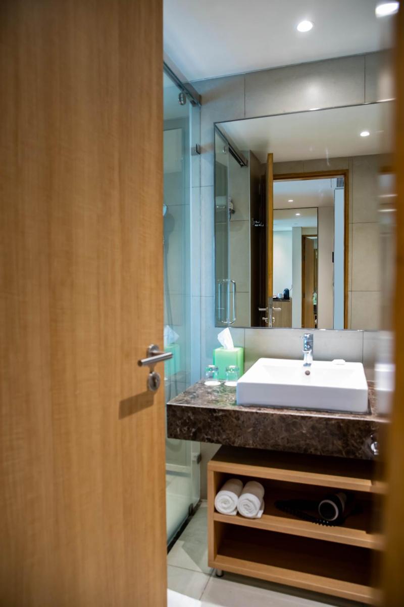 a bathroom with a sink and a large mirror at Holiday Inn Chennai OMR IT Expressway by IHG in Chennai