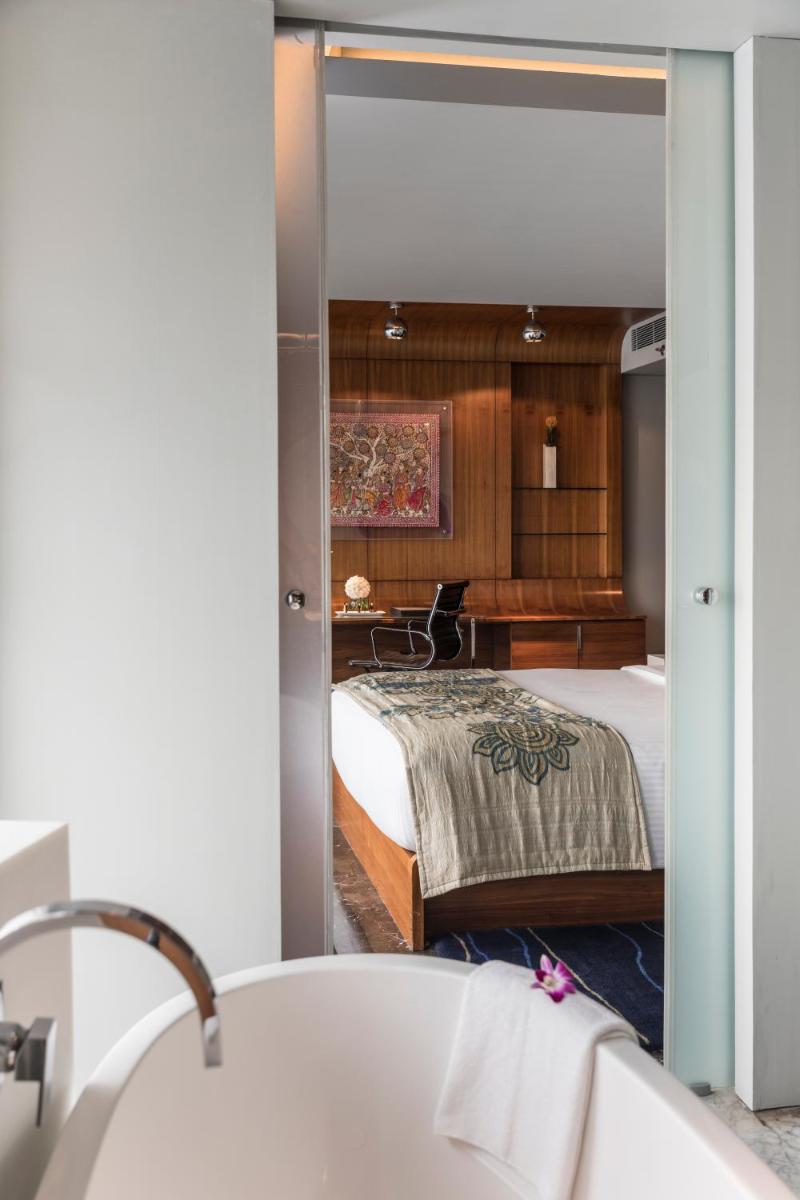 a bathroom with a tub and a bed and a mirror at The Park Hyderabad, Banjara Hills near Hussain Sagar Lake in Hyderabad a bathroom with a tub and a bed and a mirror at The Park Hyderabad, Banjara Hills near Hussain Sagar Lake in Hyderabad