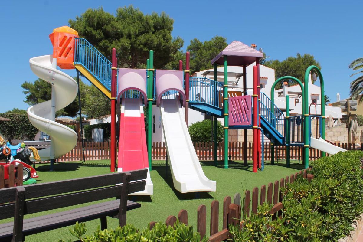 un patio de recreo con un tobogán en un parque en Apartaments Talayot, en Cala en Blanes