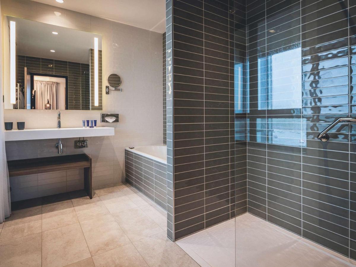 une salle de bain avec une douche, un lavabo et une baignoire dans l'établissement Sainte-Barbe Hotel & Spa Le Conquet - MGallery Collection, au Conquet