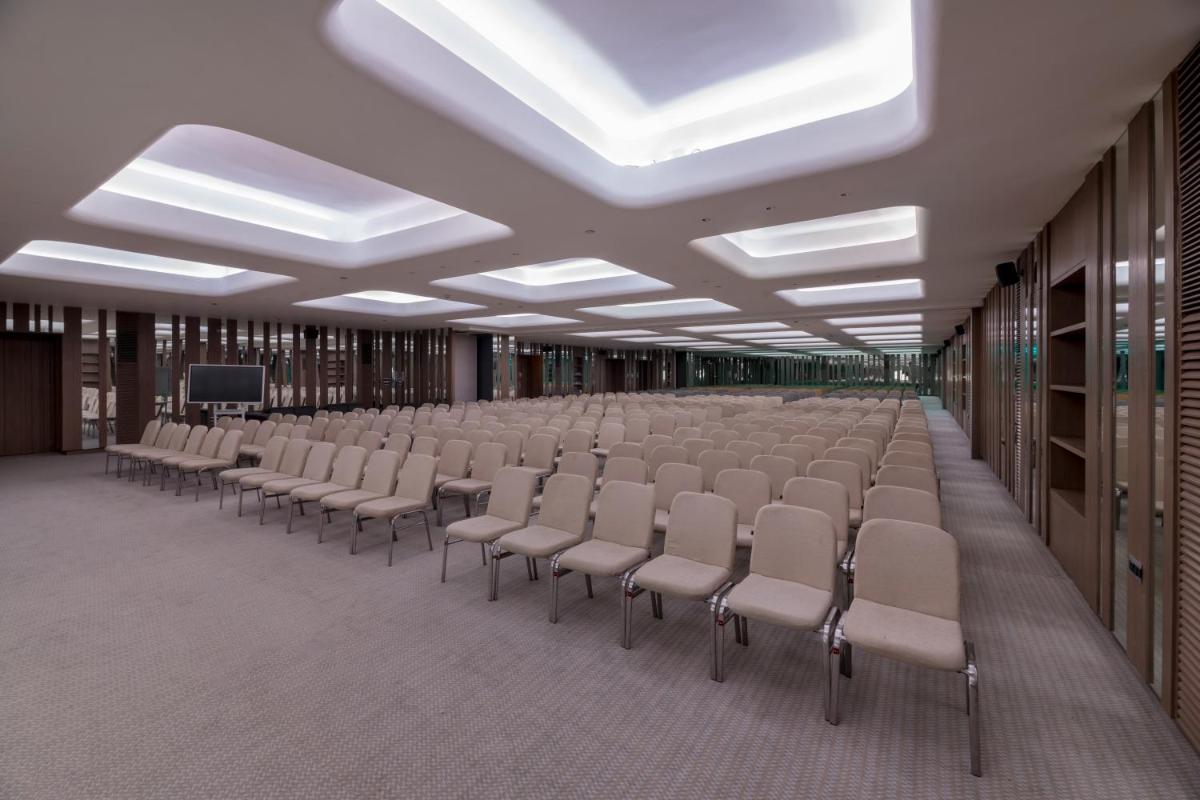 a room with rows of chairs and a television at Wyndham Ahmedabad Shela in Ahmedabad