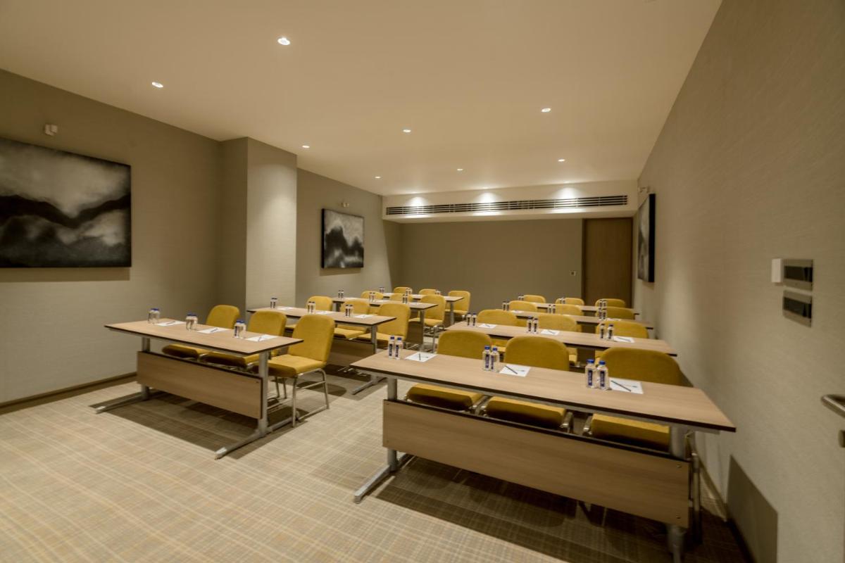 a classroom with tables and chairs in a room at Wyndham Ahmedabad Shela in Ahmedabad