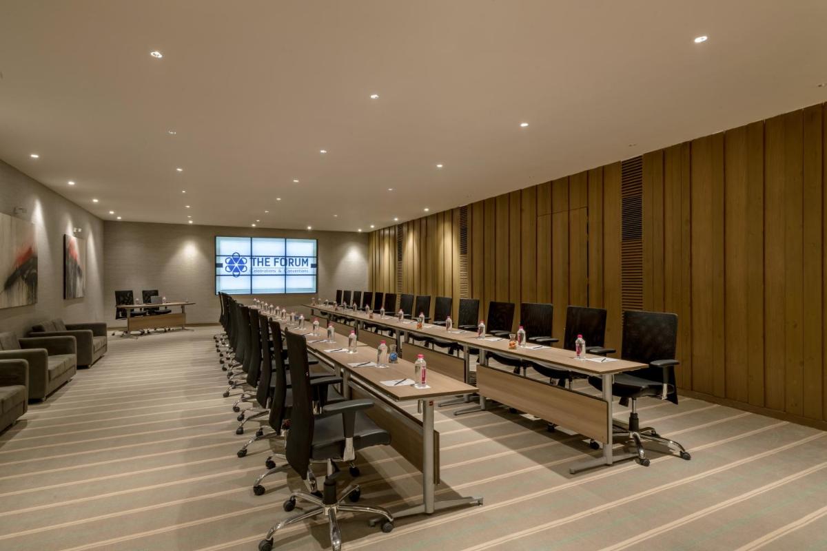 a conference room with long tables and chairs at Wyndham Ahmedabad Shela in Ahmedabad
