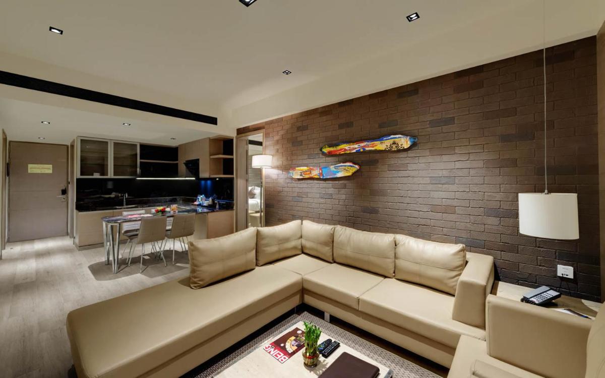 a living room with a couch and a brick wall at Wyndham Ahmedabad Shela in Ahmedabad