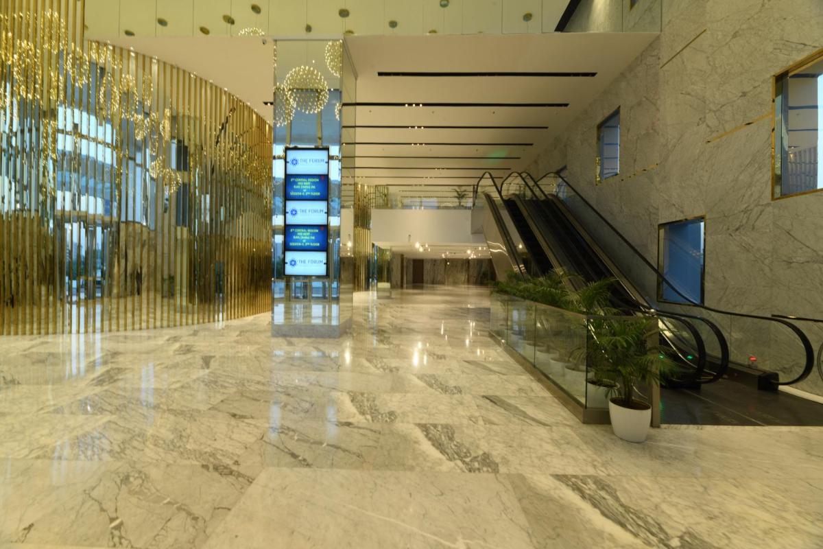 a lobby with an escalator in a building at Wyndham Ahmedabad Shela in Ahmedabad