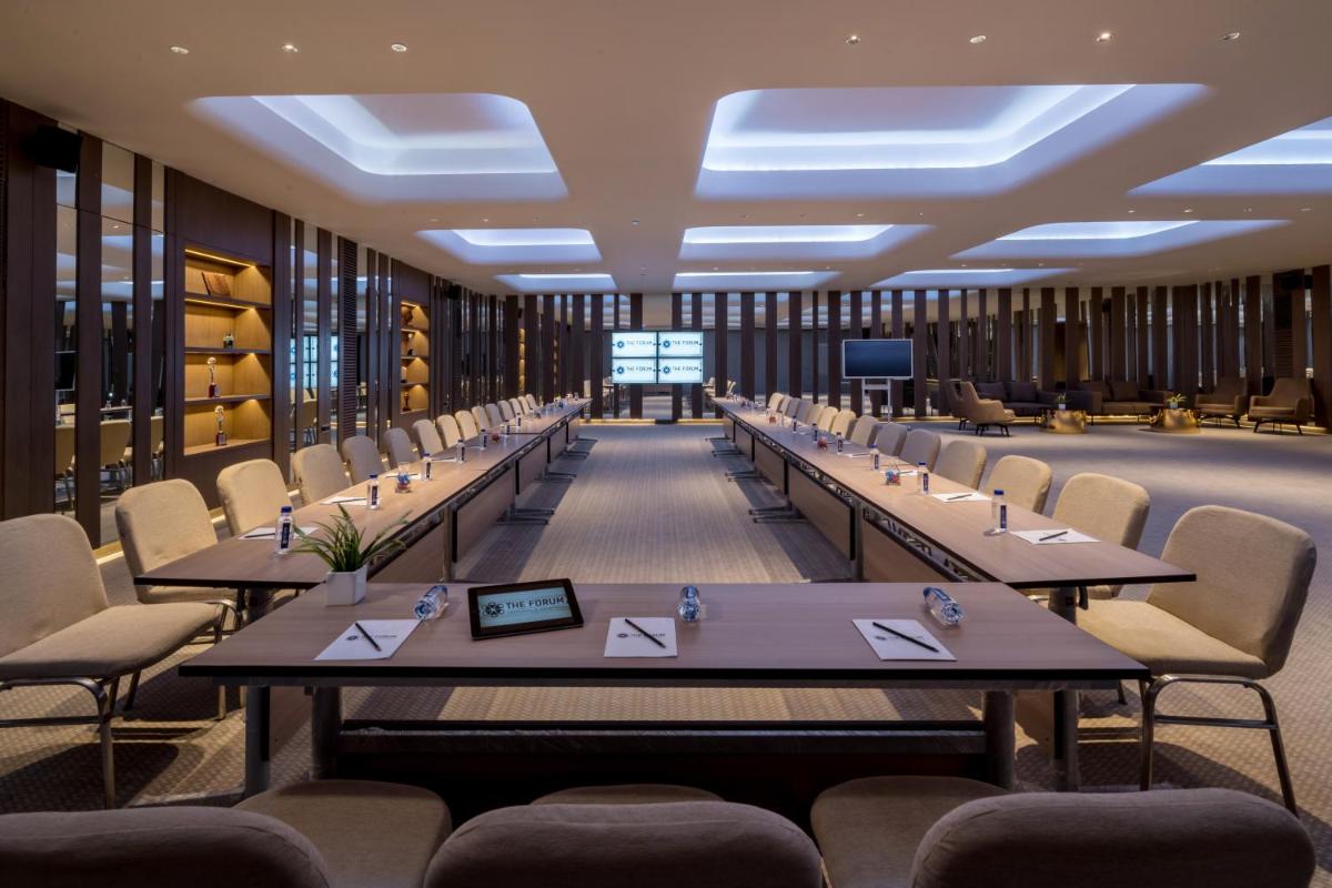 a conference room with long tables and chairs at Wyndham Ahmedabad Shela in Ahmedabad